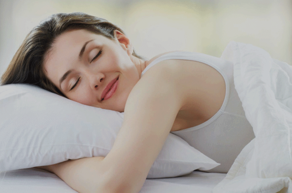 Woman sleeping on down surround pillow Nest by Nature